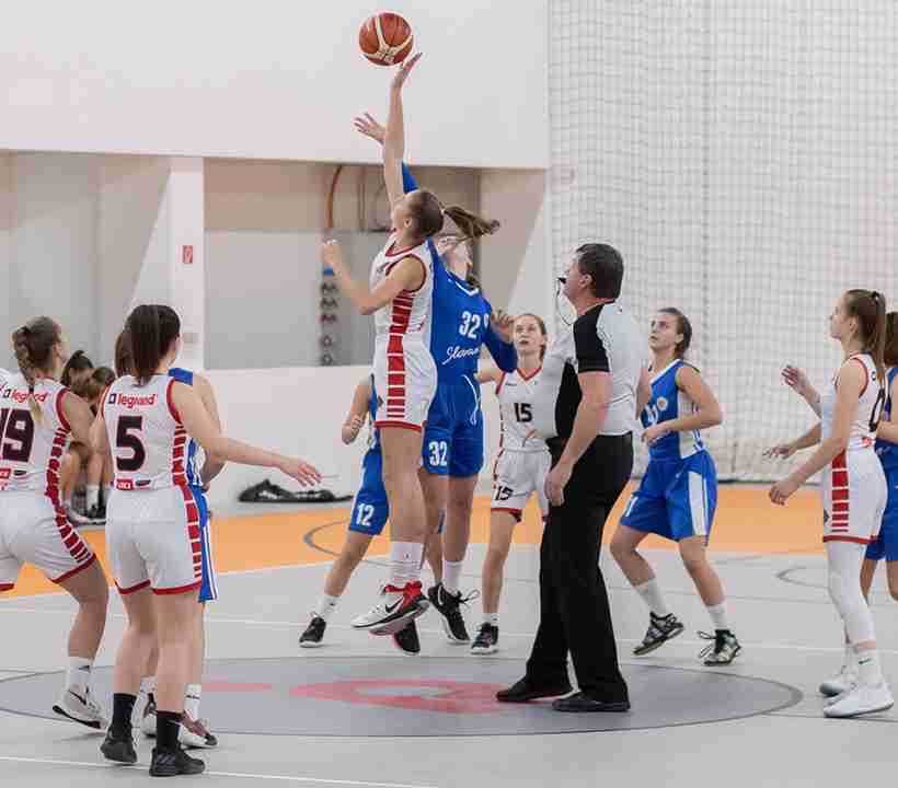 A women's basketball match in progress on a large outdoor basketball court